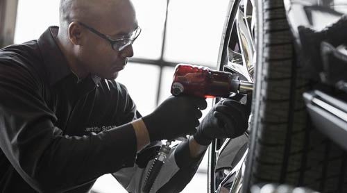 GMC Certified Service Technician performing tire change