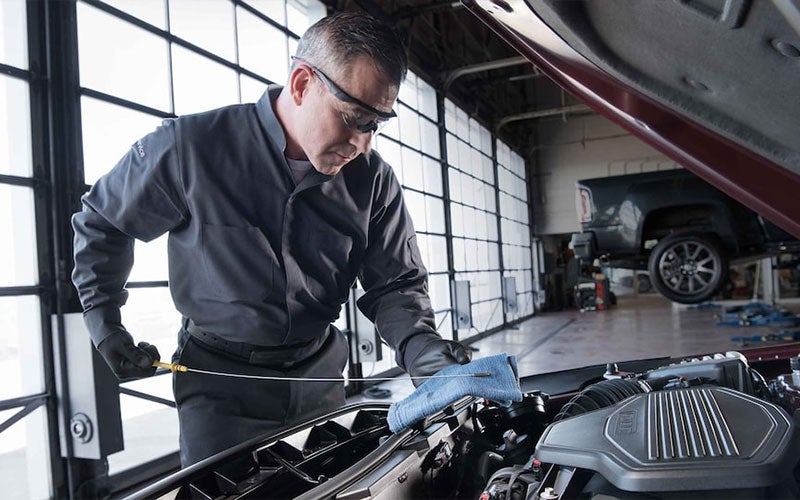 GM Service Technician performing an oil change on a GM vehicle