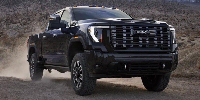 A black GMC Sierra 3500HD truck off-roading